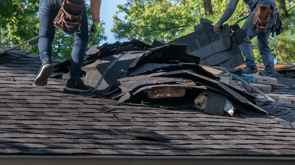 roofers tearing off an old roof on a home in michigan